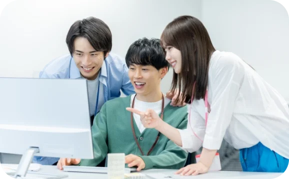 若い男女が集まって話しながら仕事している写真